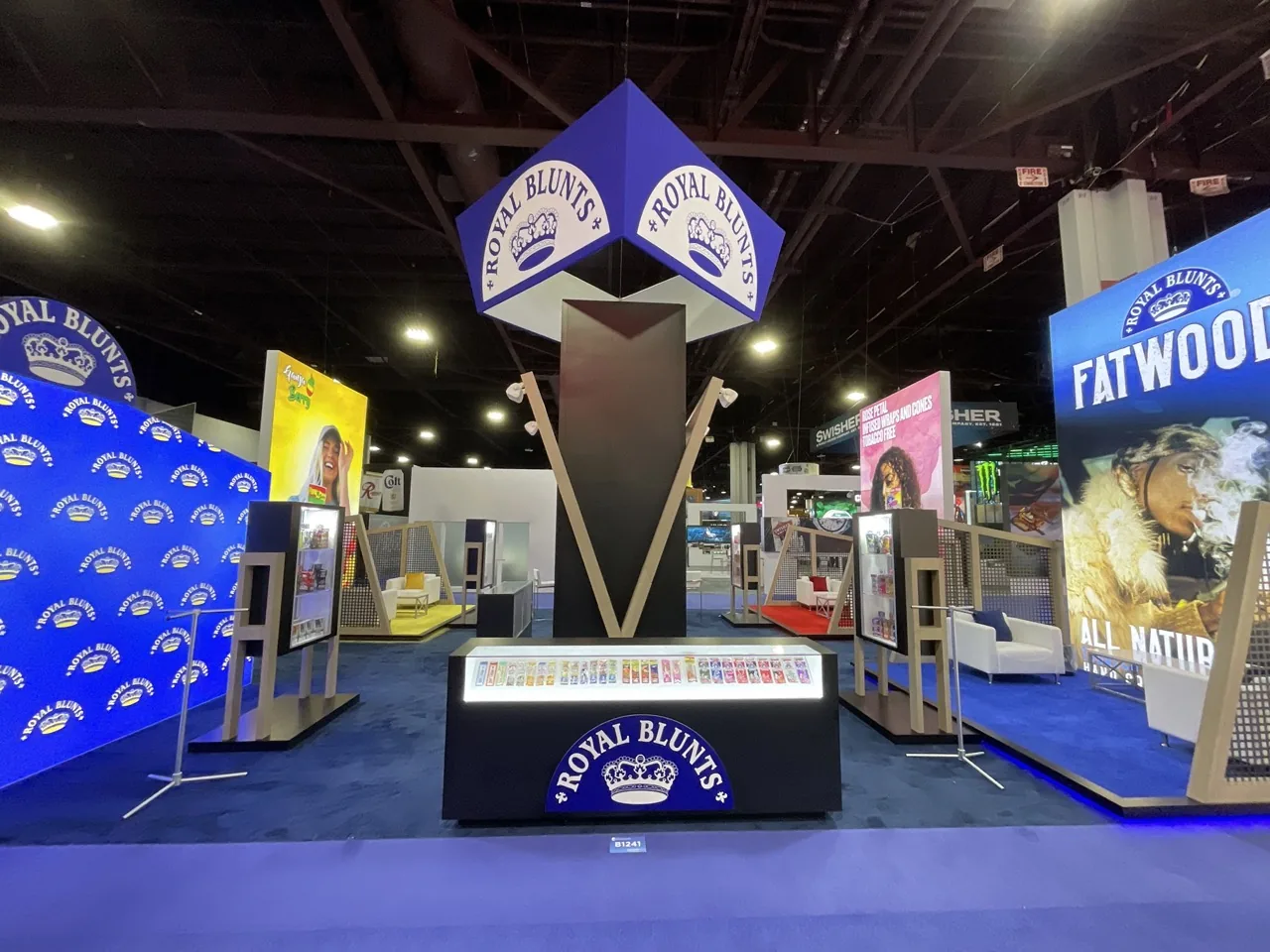 Illuminated tower exhibit on a busy show floor.